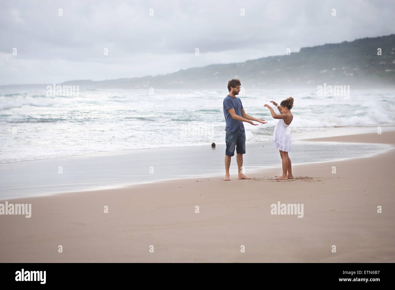 Father and daughter playing on the beach, Barbados Stock Photo