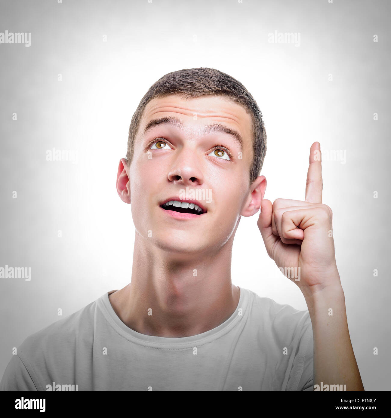Young man showing upwards index finger. Stock Photo