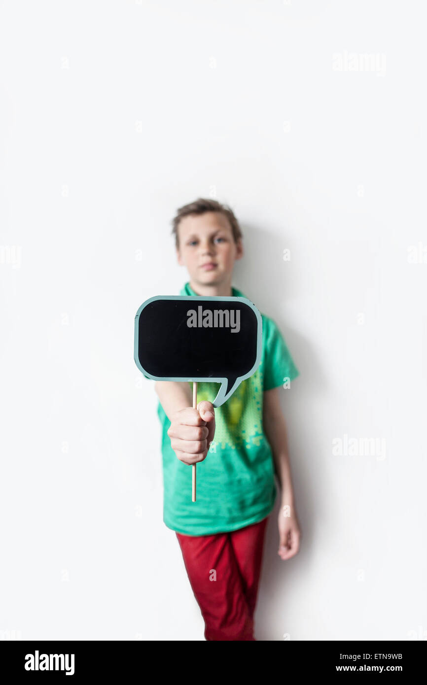 Boy holding out a thought bubble board Stock Photo