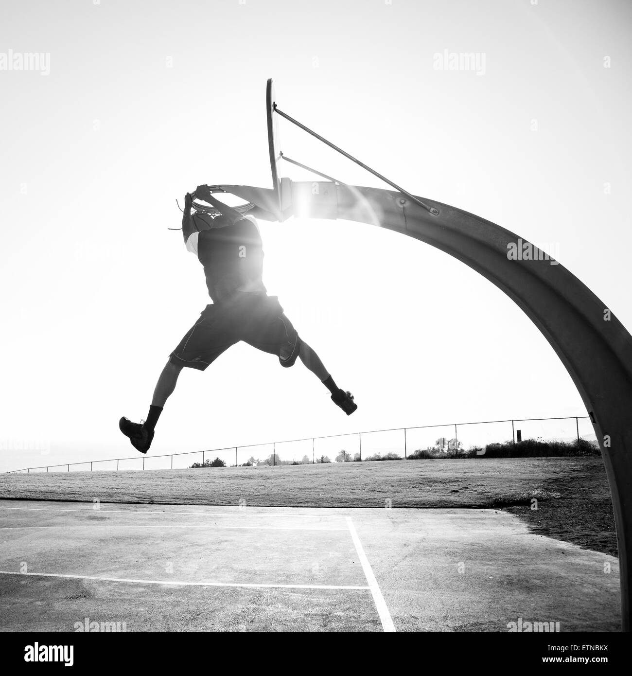 Young man shooting hoops in a park, Los Angeles, California, USA Stock