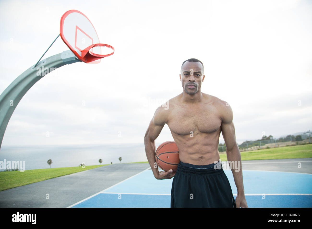 Portrait of a young man holding a basketball in a park, Los Angeles, California, USA Stock Photo