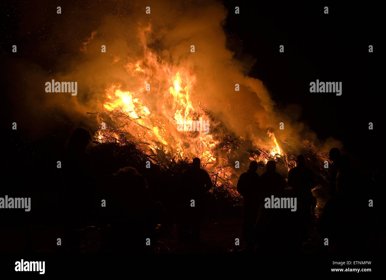 People are watching a huge bonfire, a tradition with easter in North-West Europe. Stock Photo