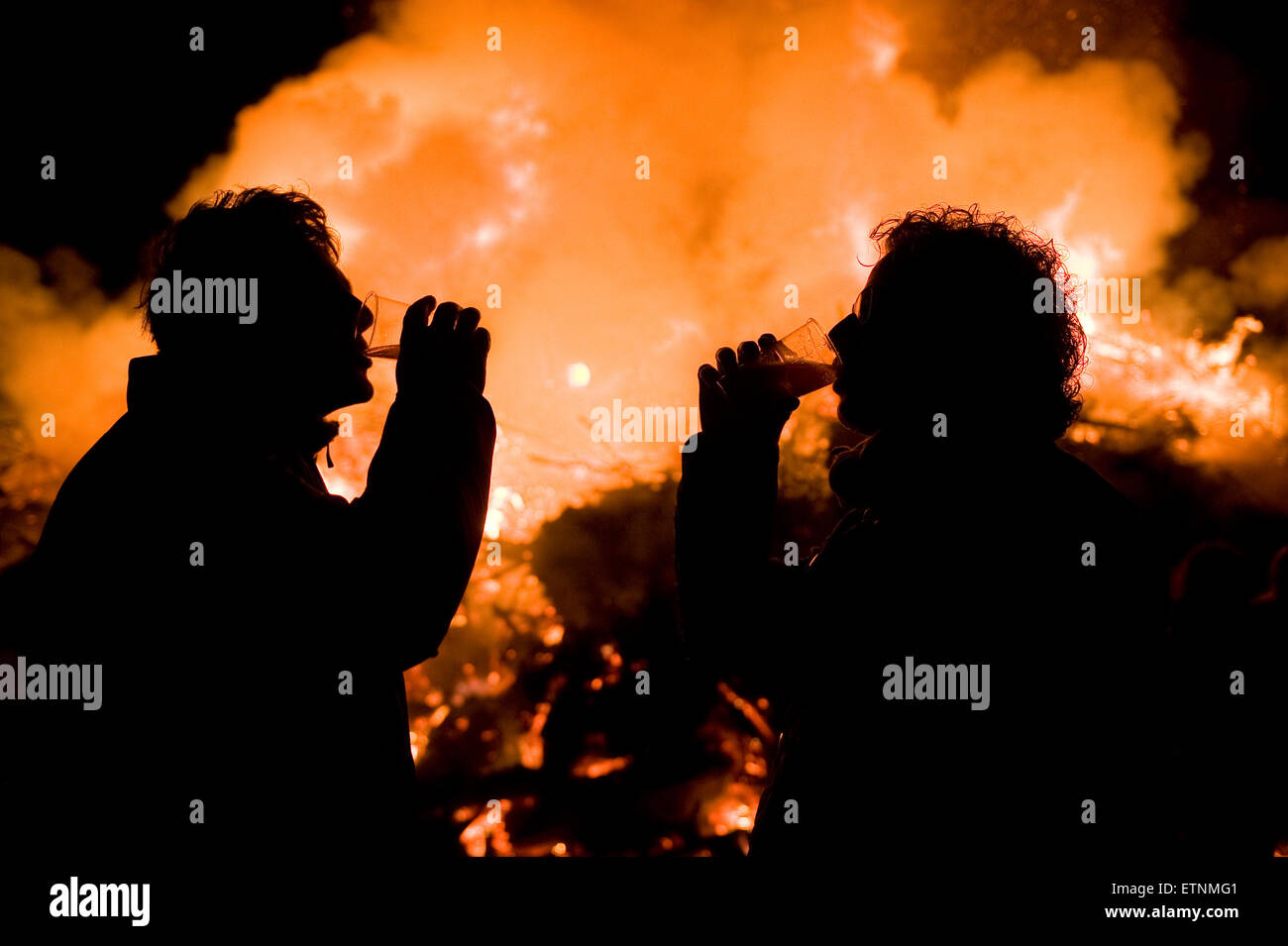 Two man drinking beer in front of a huge bonfire, a tradition with ...