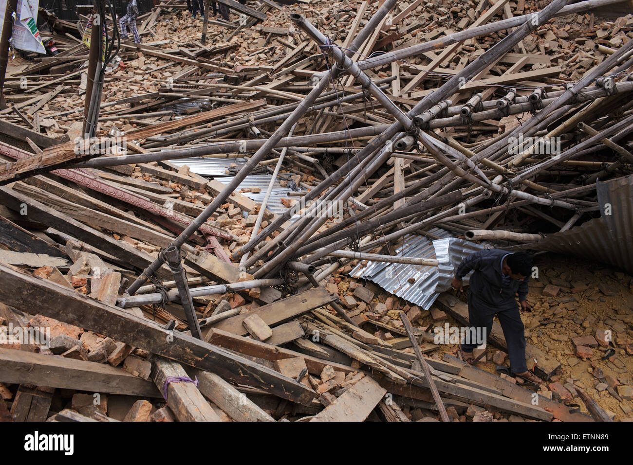 A man walks through rubble of two collapsed temples at Durbar Square. Rescue operations at Durbar Square in Kathmandu, Nepal Stock Photo