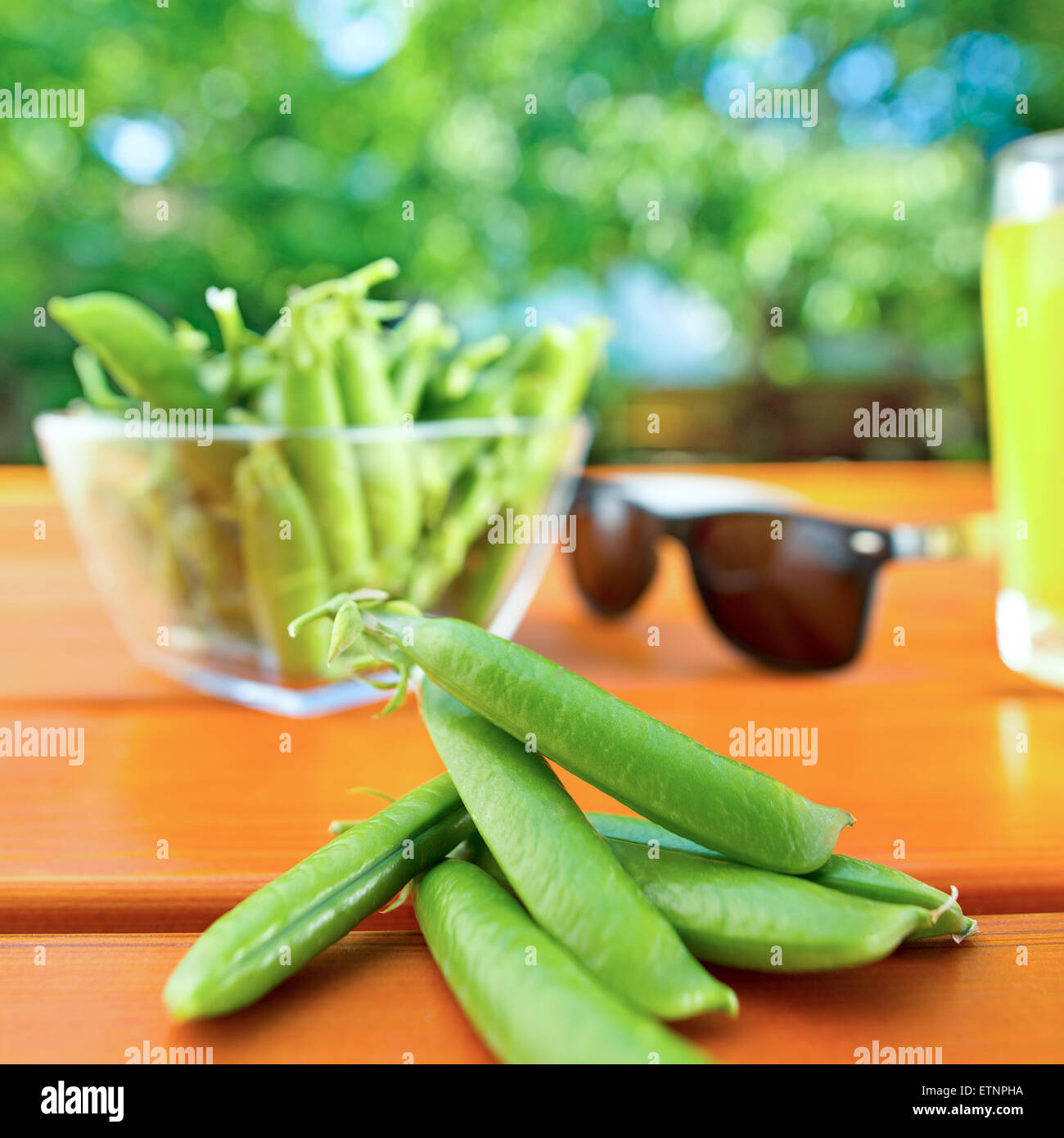 green peas with sunglasses and lemonadeon the desk in the garden Stock Photo