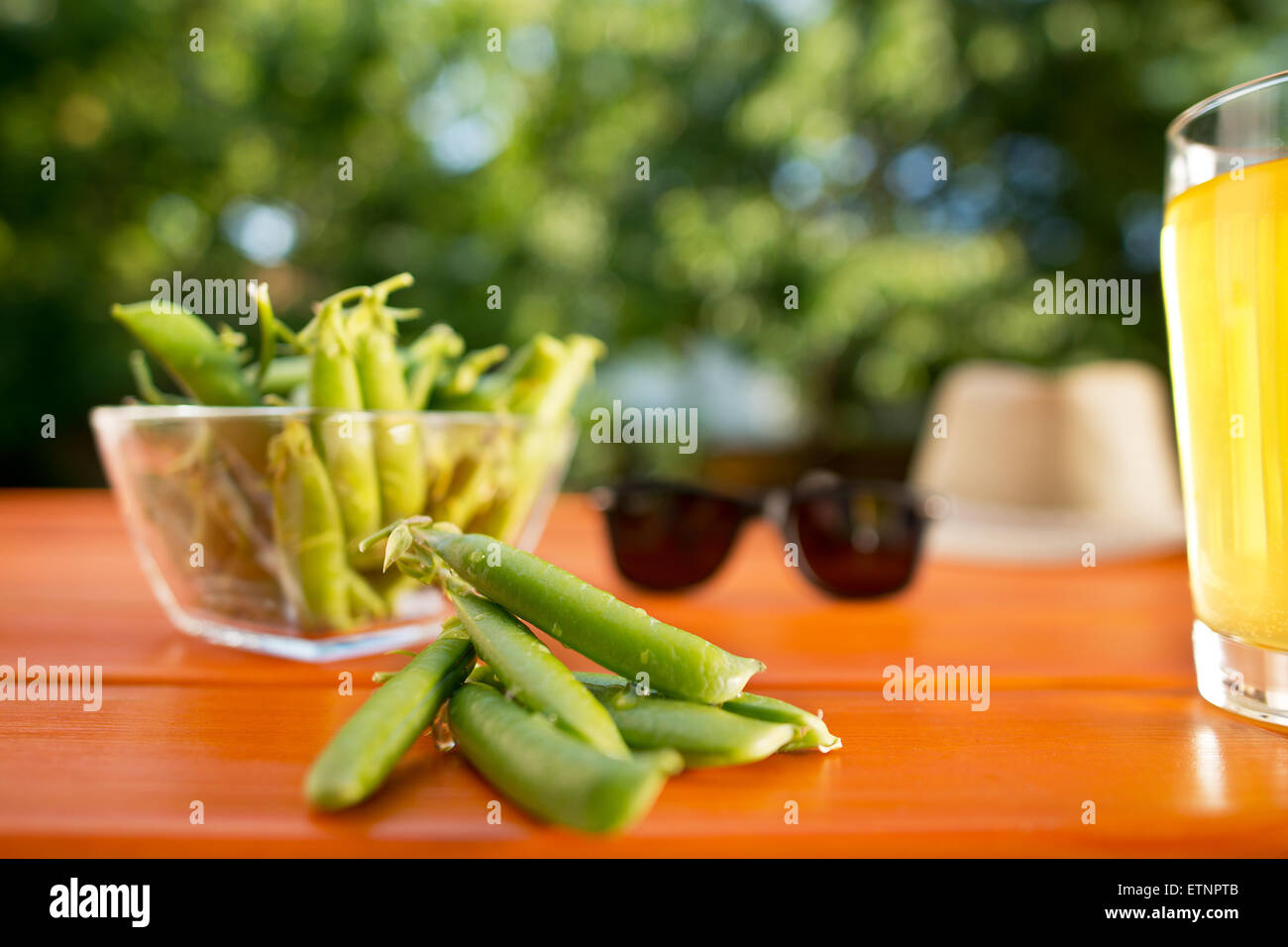 green peas with sunglasses and lemonade on the desk in the garden Stock Photo