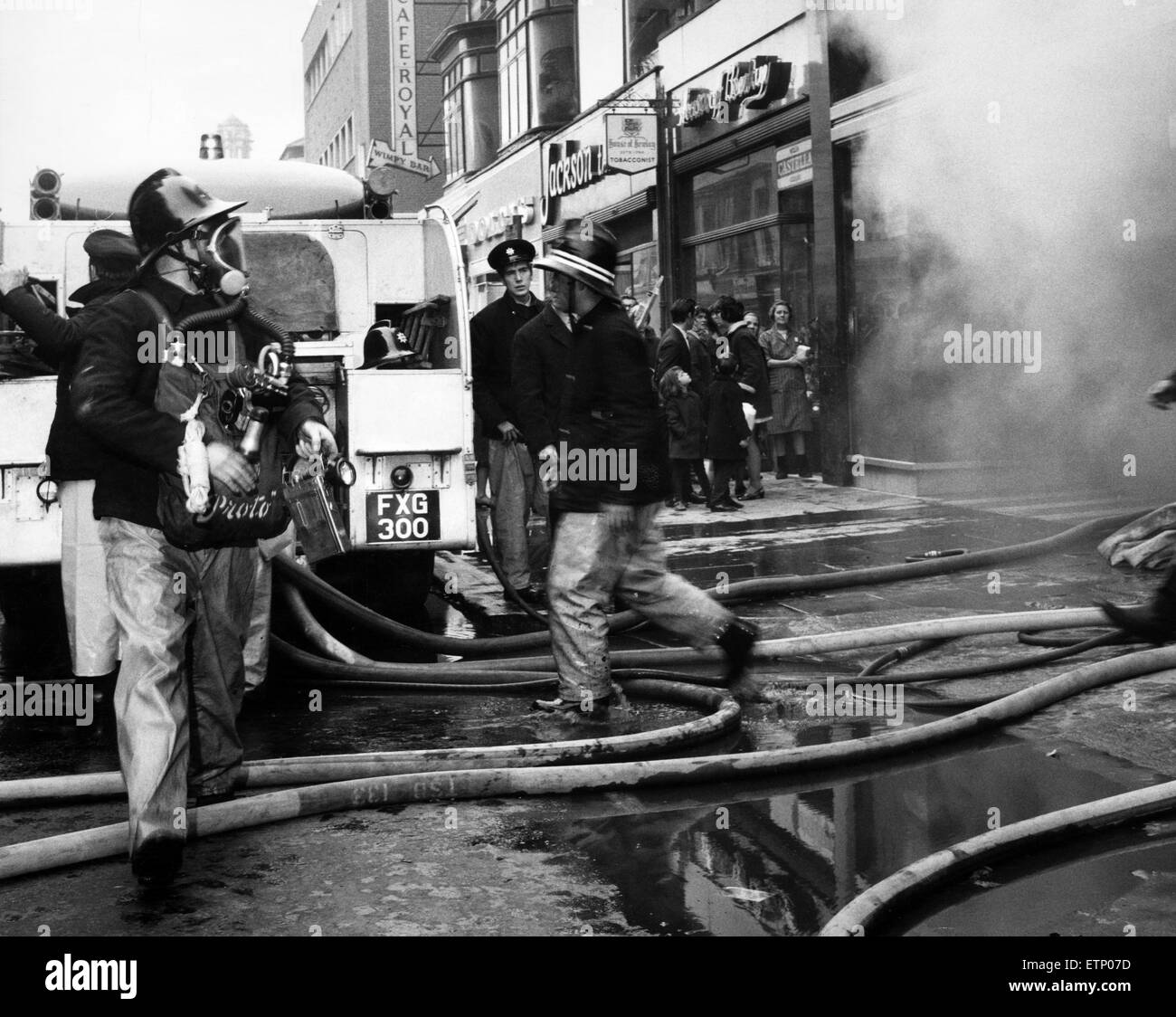 Firemen wearing breathing apparatus fight the blaze in the Saxone shoe shop, Linthorpe Road, Middlesbrough, 17th November 1970. Stock Photo