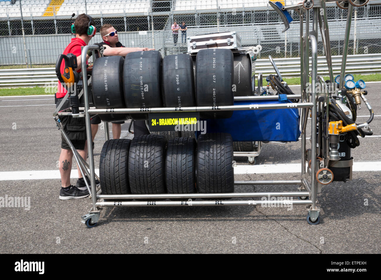Monza, Italy - May 30, 2015: A man pushes a rack of tyres at the Autodromo Nazionale di Monza Circuit Stock Photo