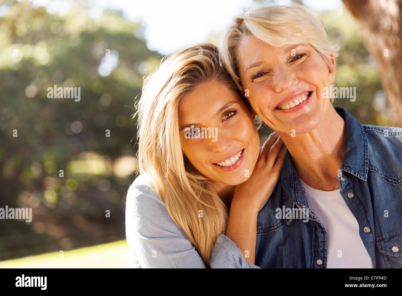 happy middle aged blond mother and adult daughter outdoors Stock Photo