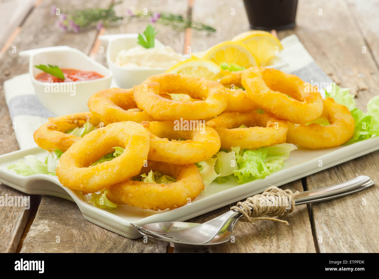 deep fried calamari with lemon and salad on white tray Stock Photo