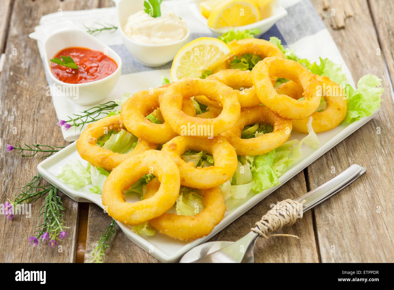deep fried calamari with lemon and salad on white tray Stock Photo