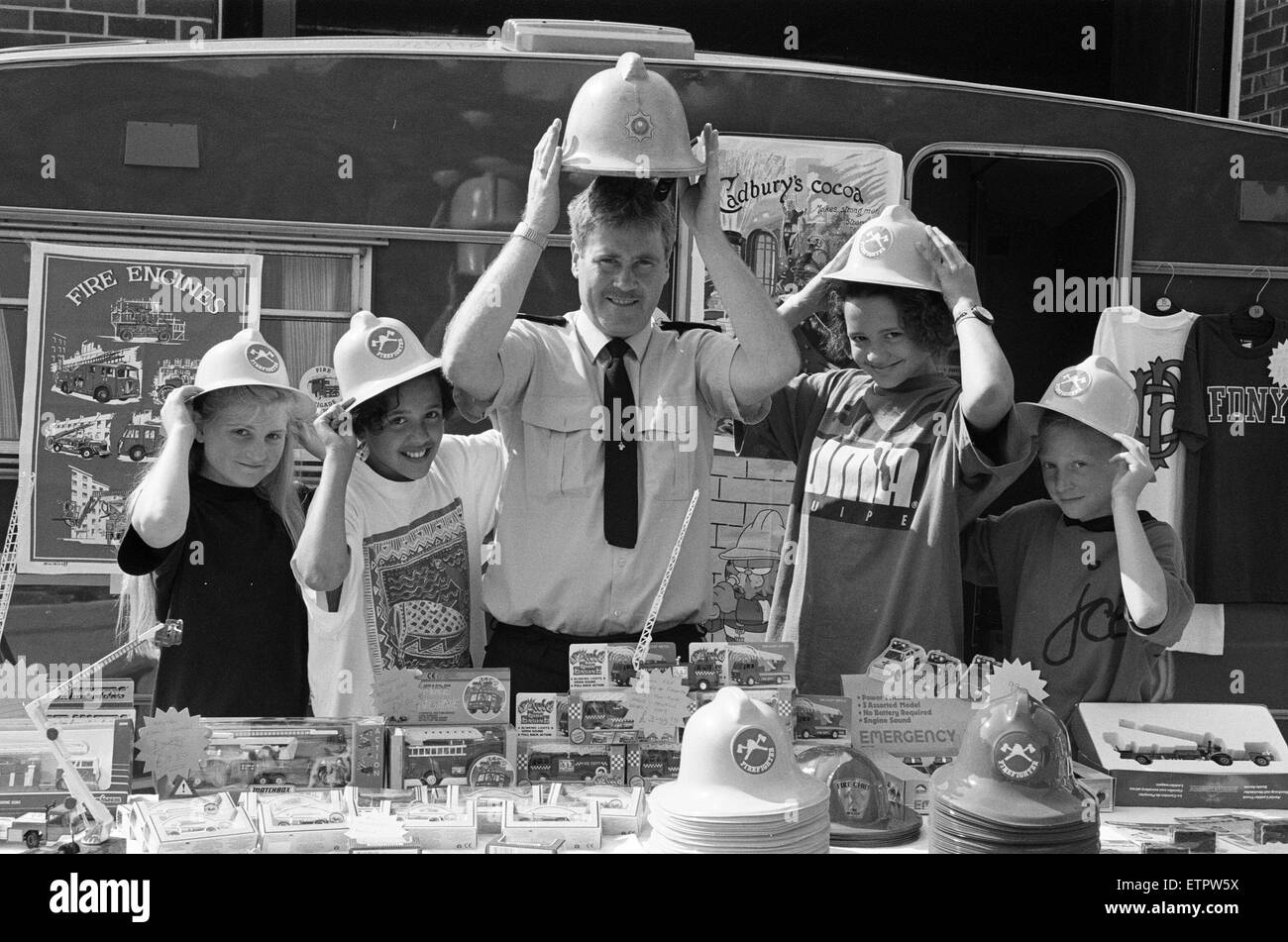 Fireman Paddy Flaherty made sure these youngsters had the right hat of the occasion when they visited Slaithwaite Fire Stations open day yesterday. Trying on minature firemen's helmets are (from left) Corinne Johnson, Angela Sykes, Katie Sykes and Karen O Stock Photo