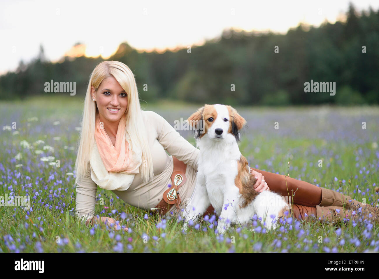 Woman, young, dog, Nederlandse Kooikerhondje, puppy, meadow, looking at camera Stock Photo
