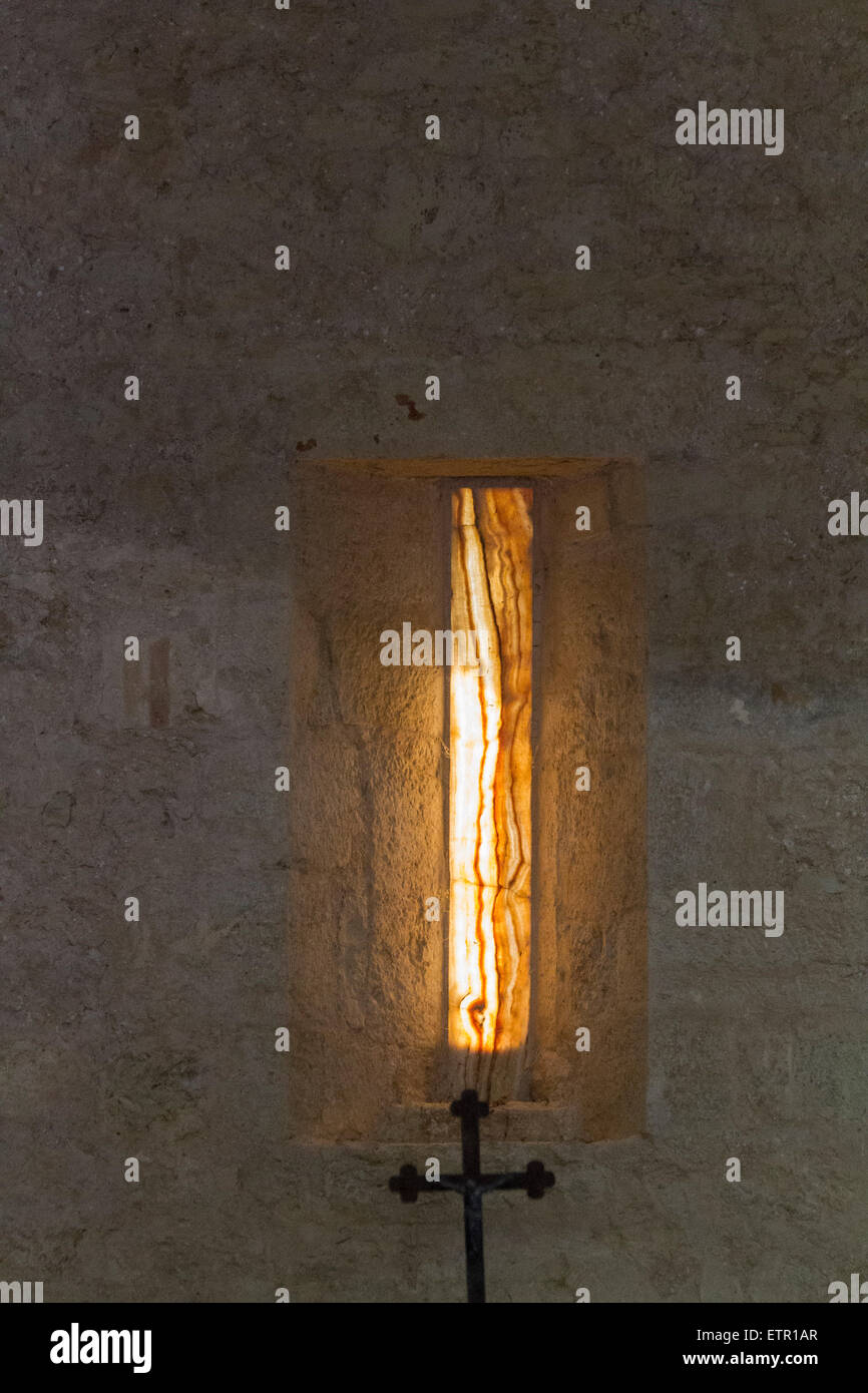 enlightened window slot with cross at church Santi Cosma e Damiano in Carsulae, Umbria, Italy, Stock Photo