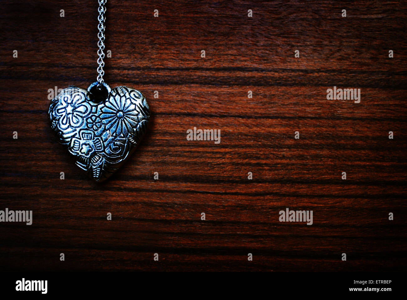 silver heart on the wood background Stock Photo