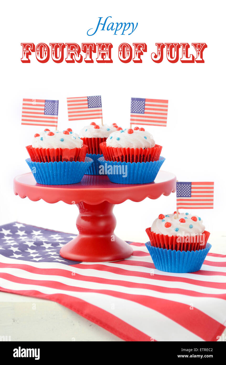 Happy Fourth of July Cupcakes on red stand with USA flags on white wood shabby chice table. Stock Photo