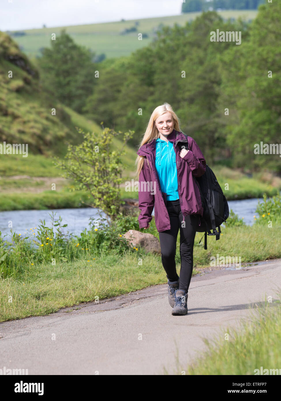 young woman hiking along path in Dovedale, Peak District National Park Stock Photo