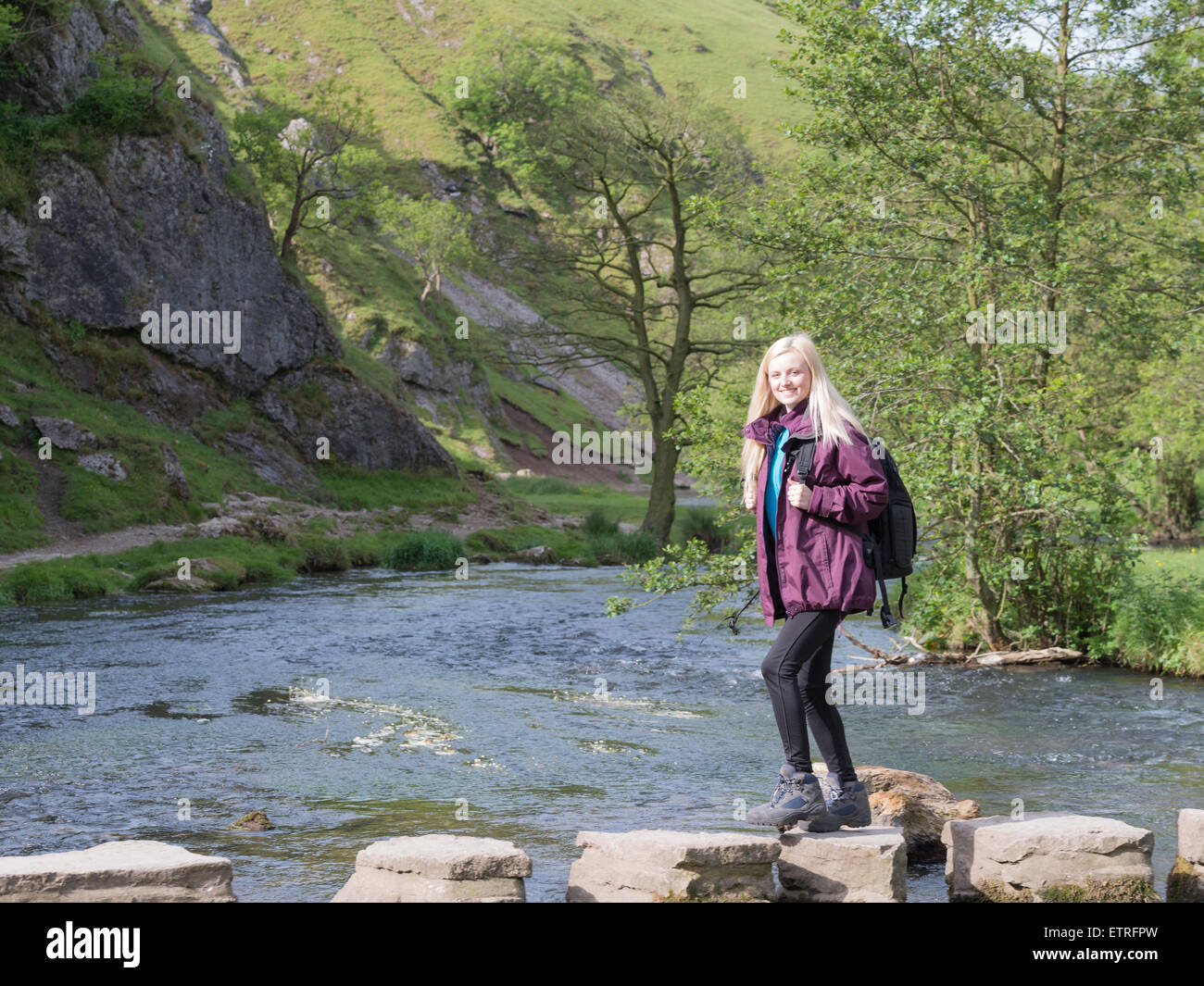 young woman walkin gin dovedale crossing stepping stones Stock Photo