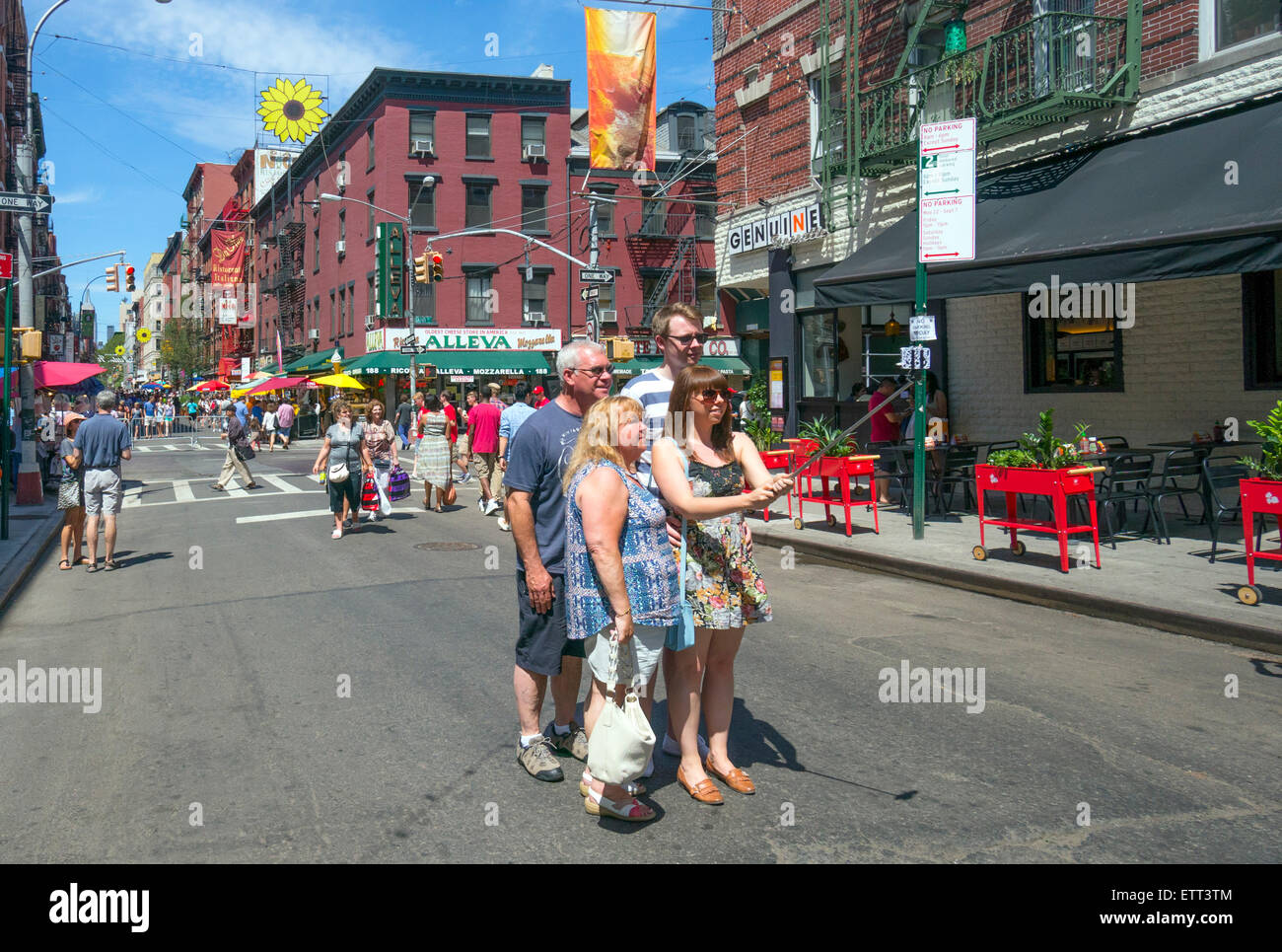 A family of tourists shooting a selfie and using an extended pole on Mulberry Street in Little Italy in NYC Stock Photo