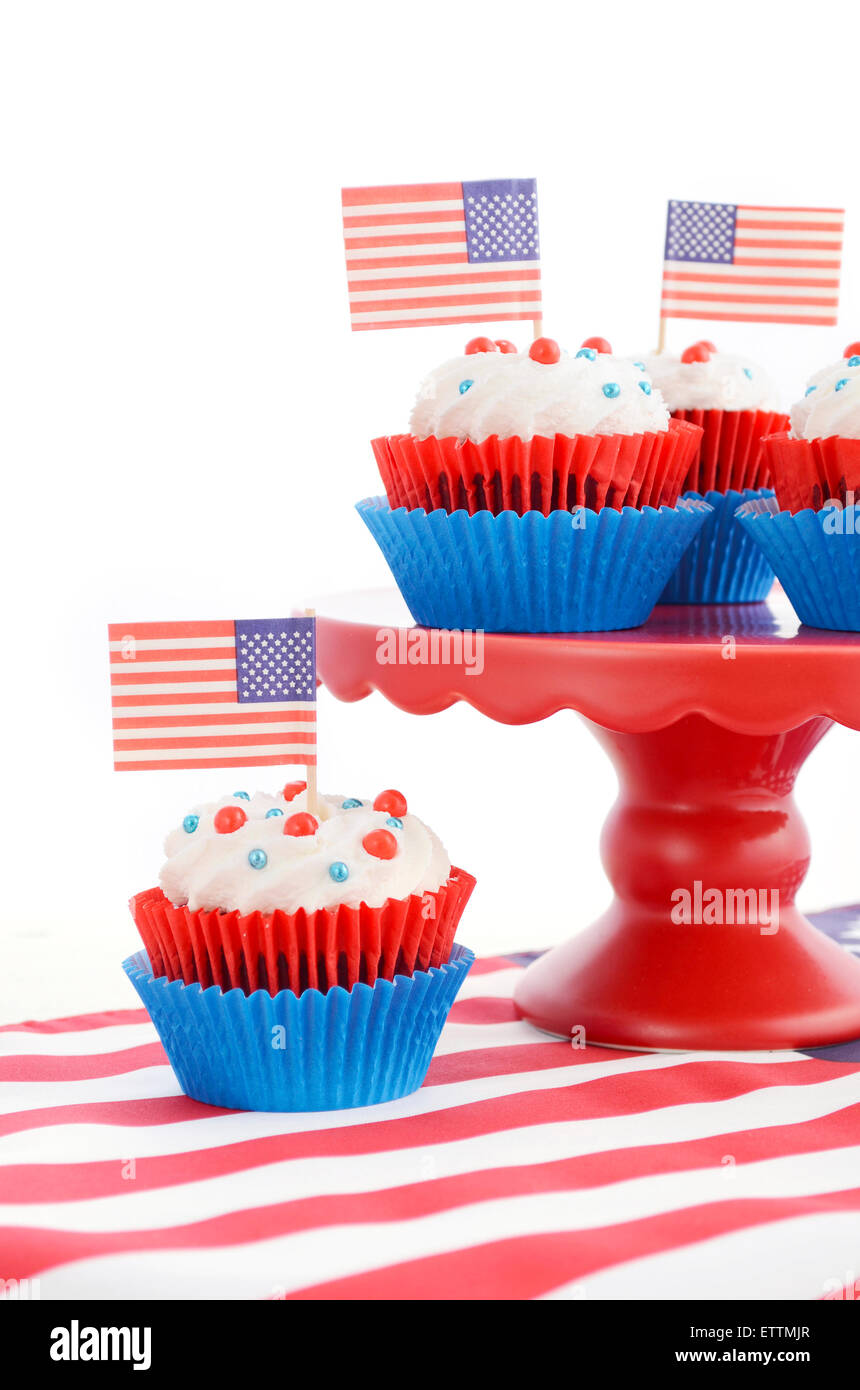Happy Fourth of July Cupcakes on red stand with USA flags on white wood shabby chice table. Stock Photo