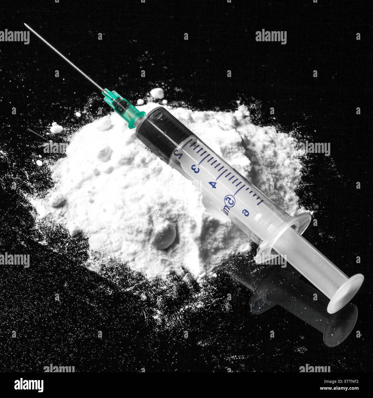 Drug syringe and cooked heroin on spoon Stock Photo