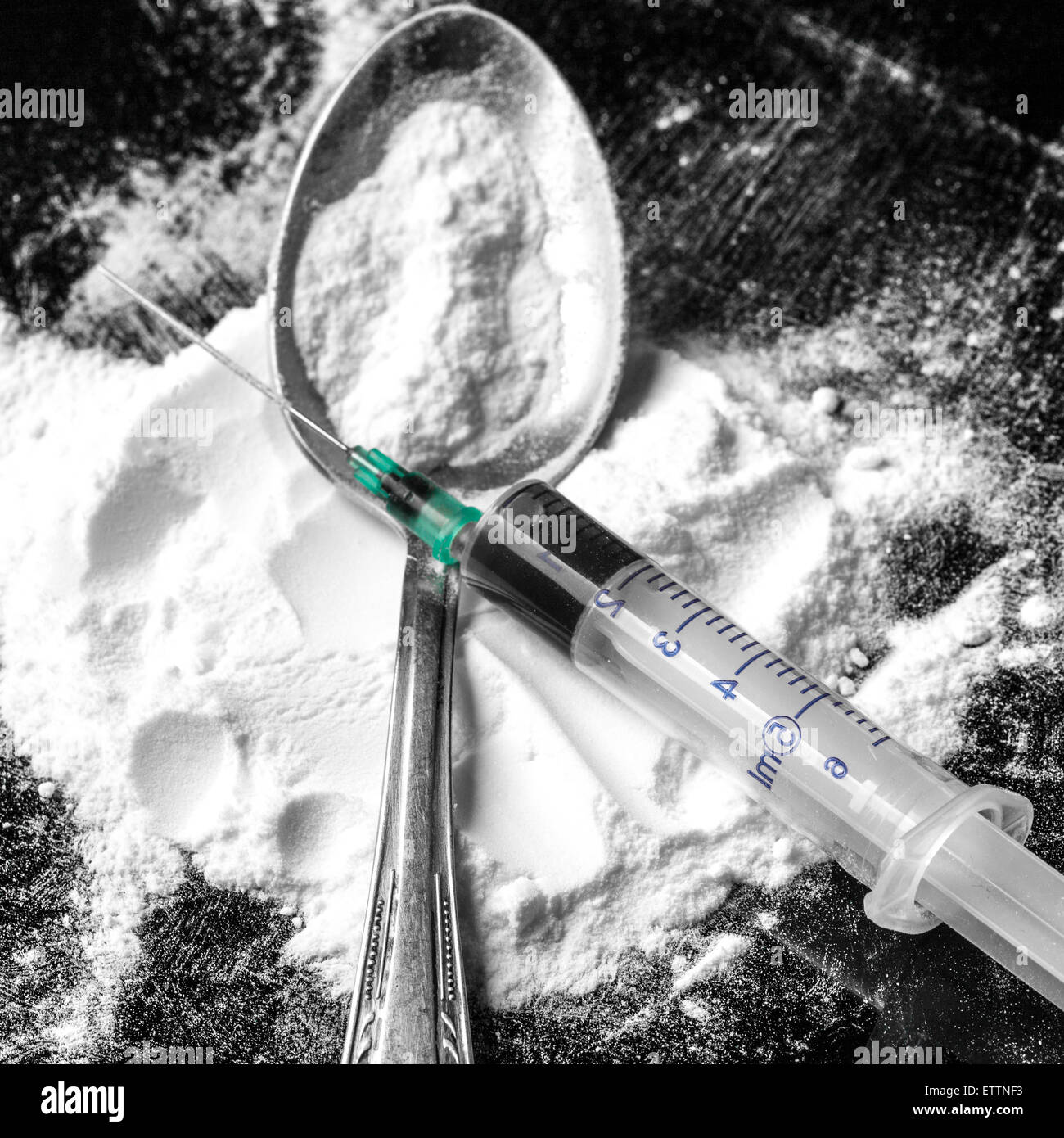 Drug syringe and cooked heroin on spoon Stock Photo