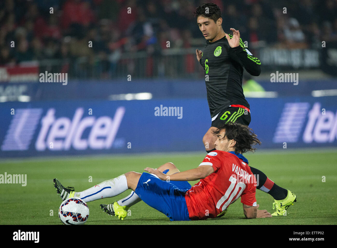 Santiago, Chile. 15th June, 2015. Jorge Valdivia (Bottom) of Chile vies for the ball with Javier Guemez of Mexico during the the Group A match of the Copa America 2015, at the National Stadium, in Santiago, Chile, on June 15, 2015. The match ended with a 3-3 draw. Credit:  Pedro Mera/Xinhua/Alamy Live News Stock Photo