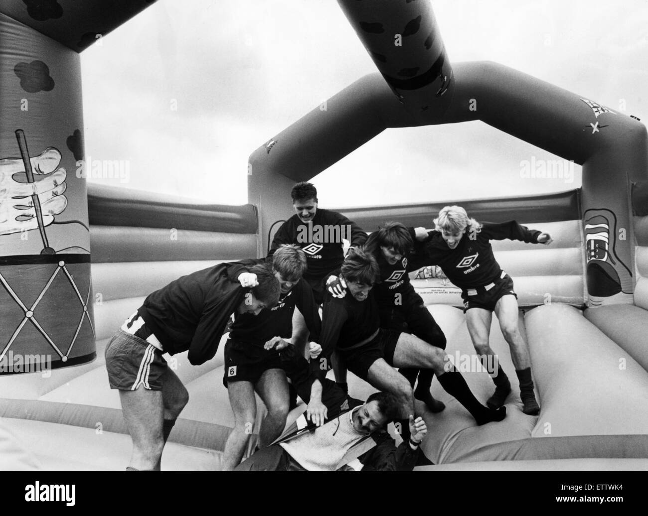 Newcastle United 1986, Pre Season. Players take time out on a inflatable bouncing castle at their Benwell training ground to help publicise Bounce Aid, the latest North East answer to Band Aid. 18th August 1986. Pictured. Organiser John Stokel Walker with Stock Photo