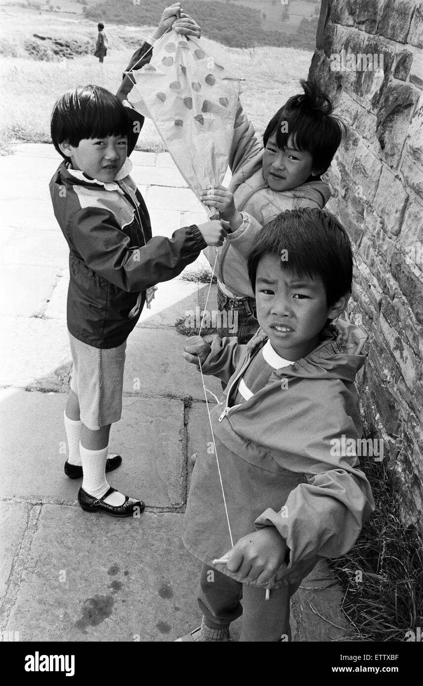 Ready for take off-these youngsters were among a group of some 25 children flying home made kites at Castle Hill as part of a play scheme organized by the National Children's Centre of Longroyd Bridge.  From left are Marie Lau, Wing Lun Liu and Andy Chu.  The play scheme has been funded by Huddersfield Cinderella Society.  Other activities included five a side football, mask making and mural painting. 12th August 1985. Stock Photo