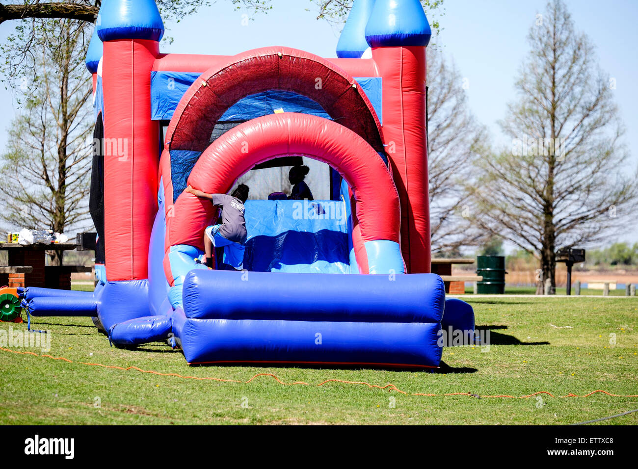 A teenage African American girl and a boy play in an inflatable bounce castle. Oklahoma City, Oklahoma, USA. Stock Photo