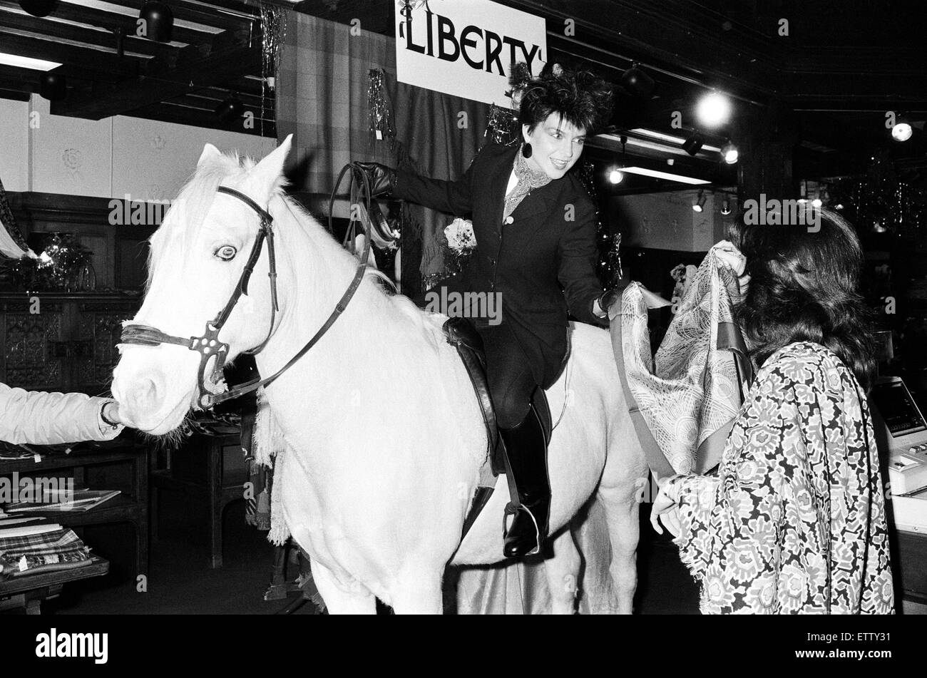 Pop singer and actress Toyah Willcox has always wanted to do her Christmas shopping on horseback! With a little help from TV-am's 'Fantasy Time', and Liberty's in Regent Street, Toyah rode a white horse called Messenger through the store. Shop assistants Stock Photo