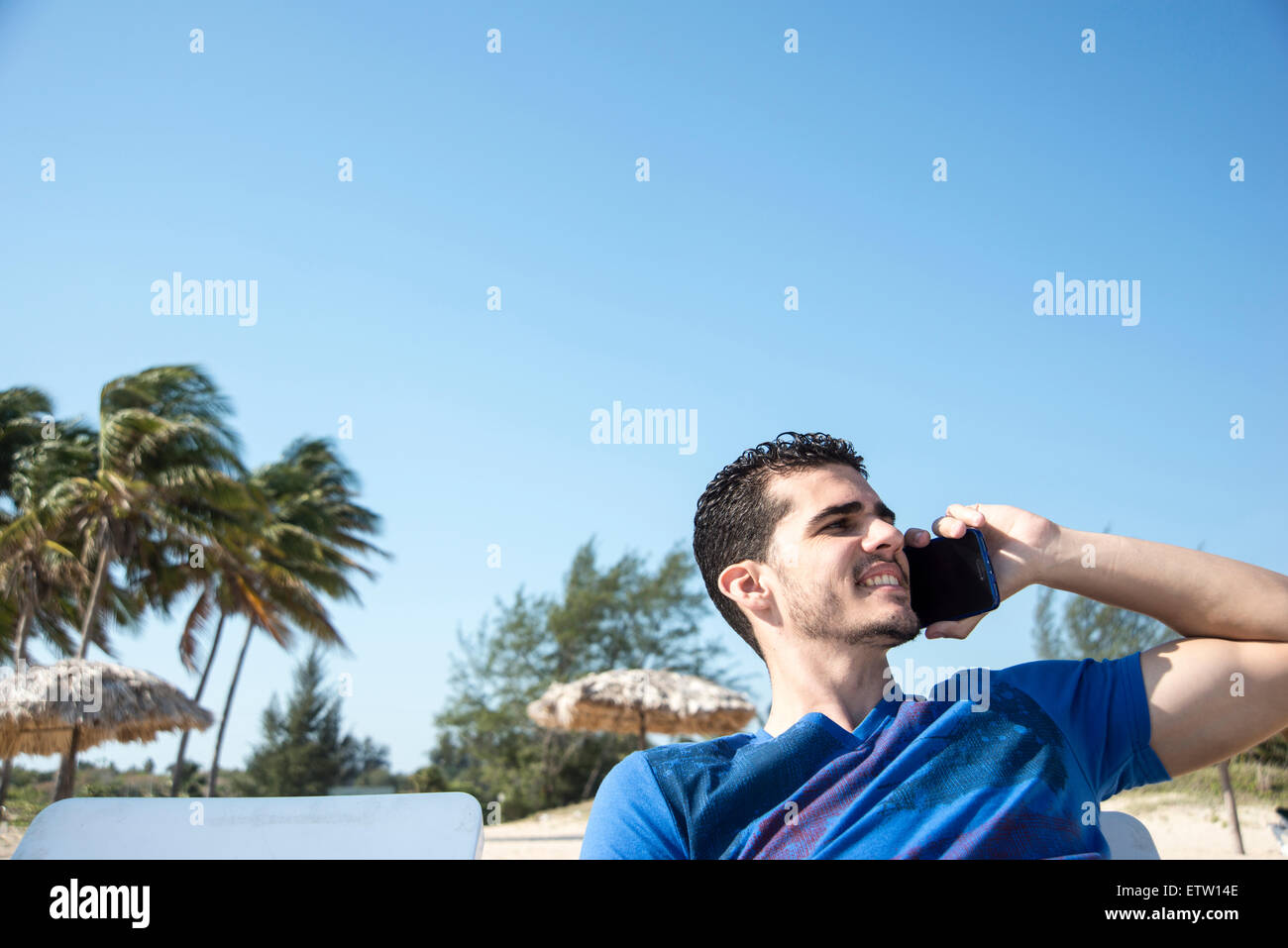 Young man using mobile phone on beach Stock Photo