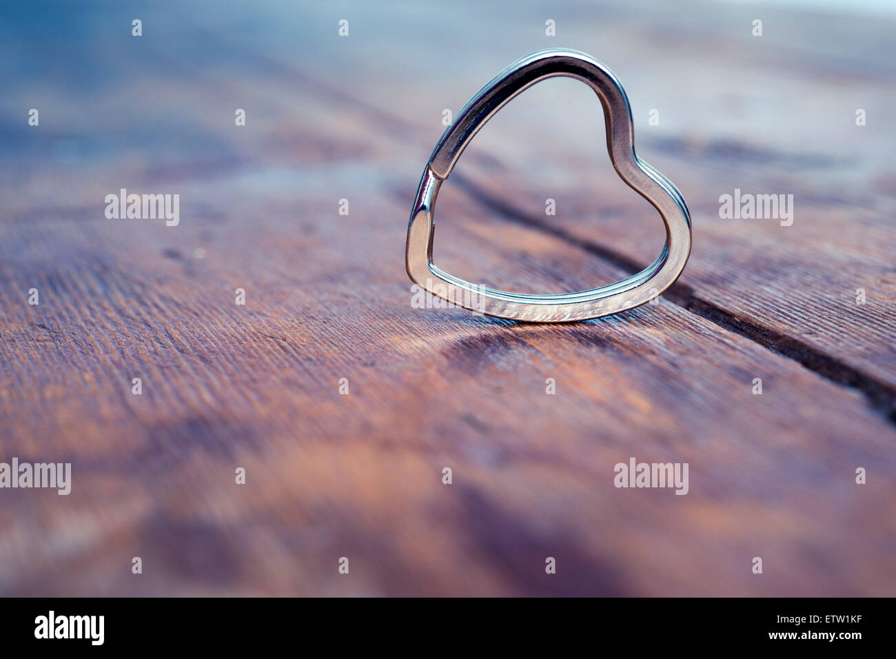 simple metallic heart on the vintage wood background with shallow depth of field Stock Photo