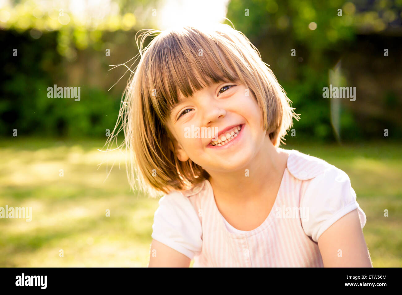 Portrait of smiling little girl in a garden Stock Photo - Alamy