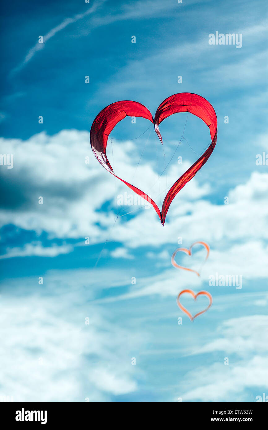 Red heart-shaped kites in the air Stock Photo