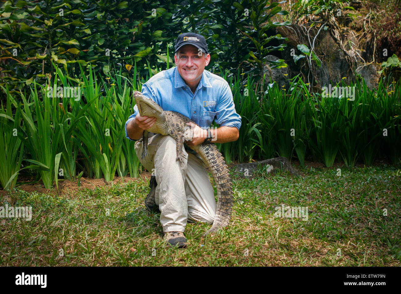 Herpetologist Brady Barr poses with juvenile freshwater crocodile on promotional program at Safari Park of Cisarua, Indonesia. Stock Photo