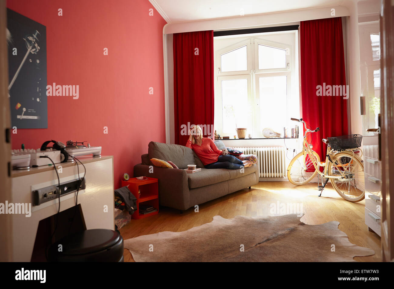 Young woman relaxing on couch at home Stock Photo - Alamy