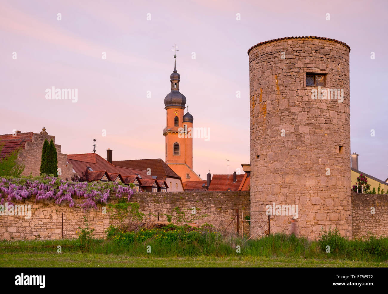 Germany, Bavaria, Lower Franconia, Eibelstadt, City wall with Hangman's Tower and Parish Church St. Nikolaus, afterglow Stock Photo