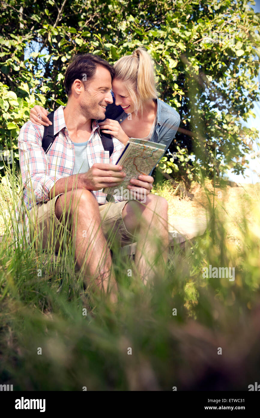 Happy hiking couple with map taking a break Stock Photo - Alamy