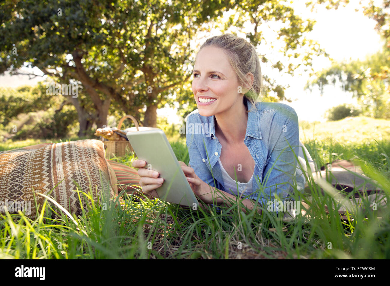 Smiling woman with digital tablet lying on meadow Stock Photo - Alamy
