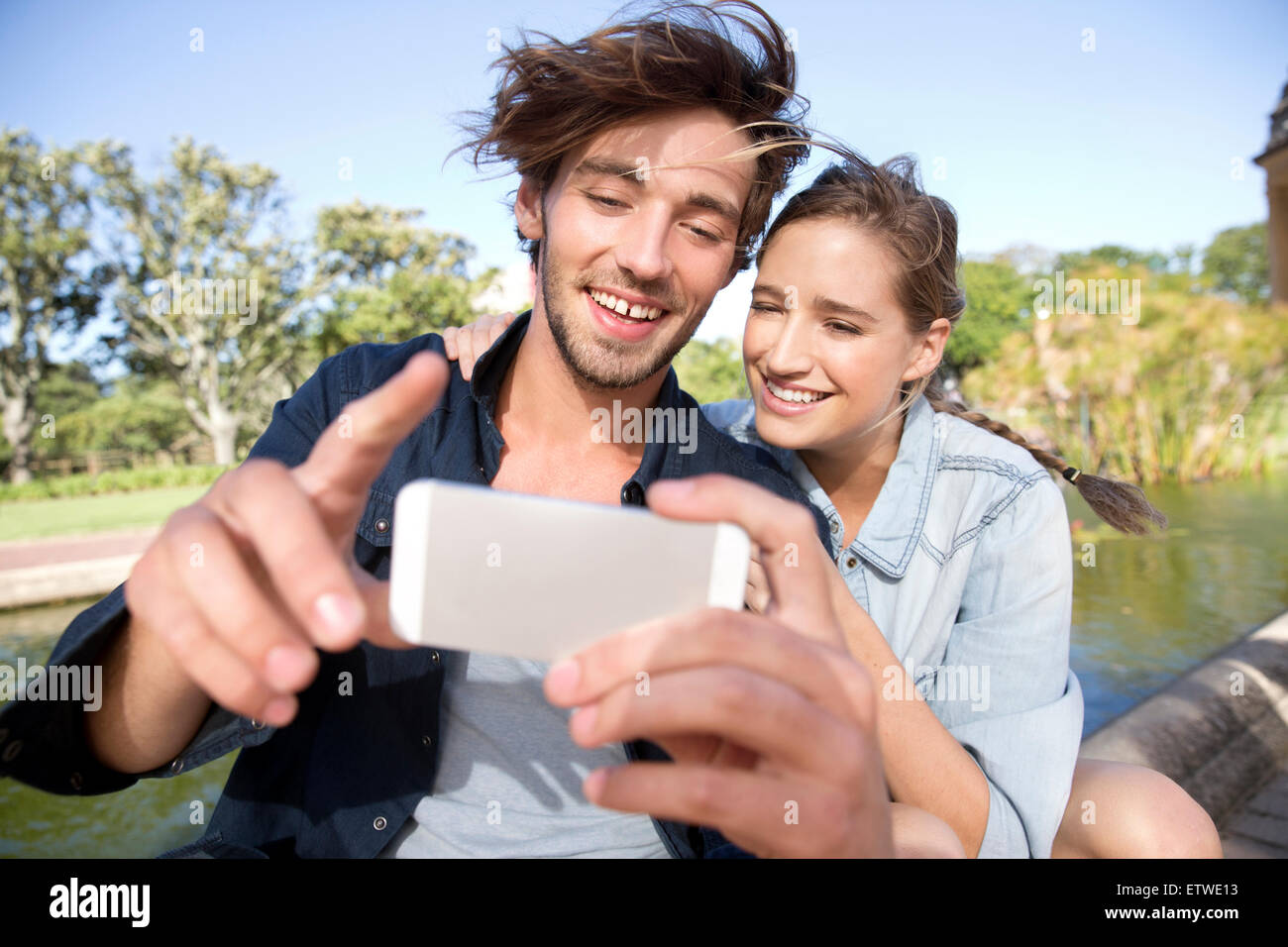 Happy young couple in park taking a selfie Stock Photo - Alamy