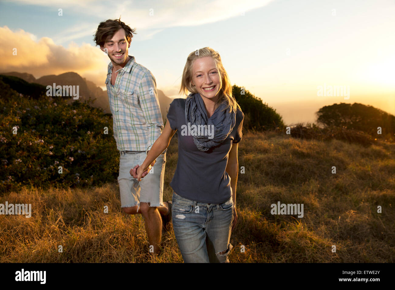 Young couple walking hand in hand in remote landscape Stock Photo - Alamy