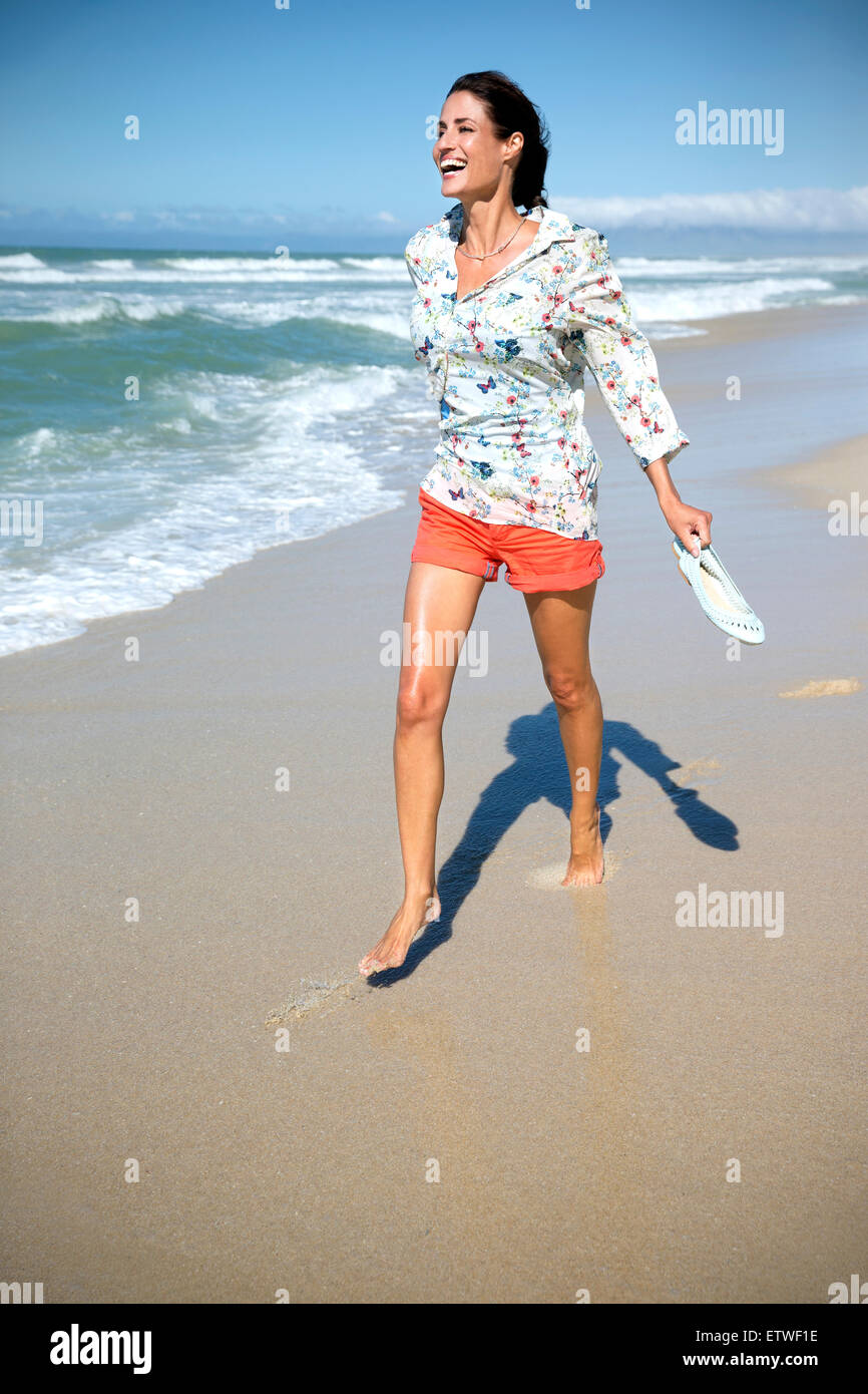 Mature woman running along the beach hi-res stock photography and images -  Alamy