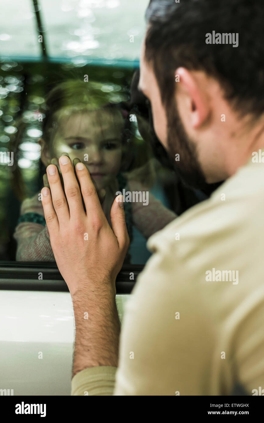 Girl in car looking at father behind window pane Stock Photo Alamy