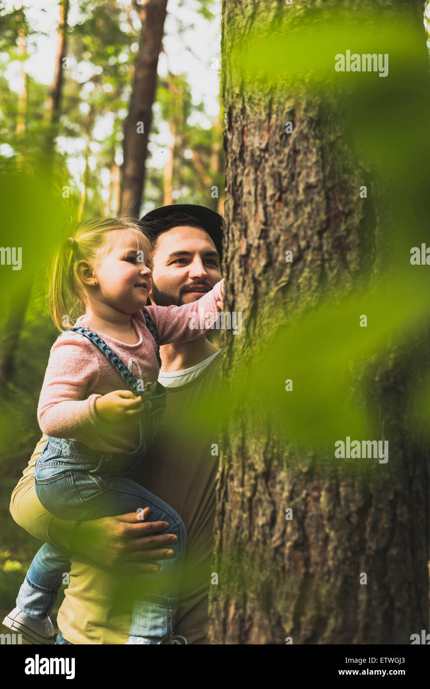 Girl with father in forest examining tree trunk Stock Photo - Alamy