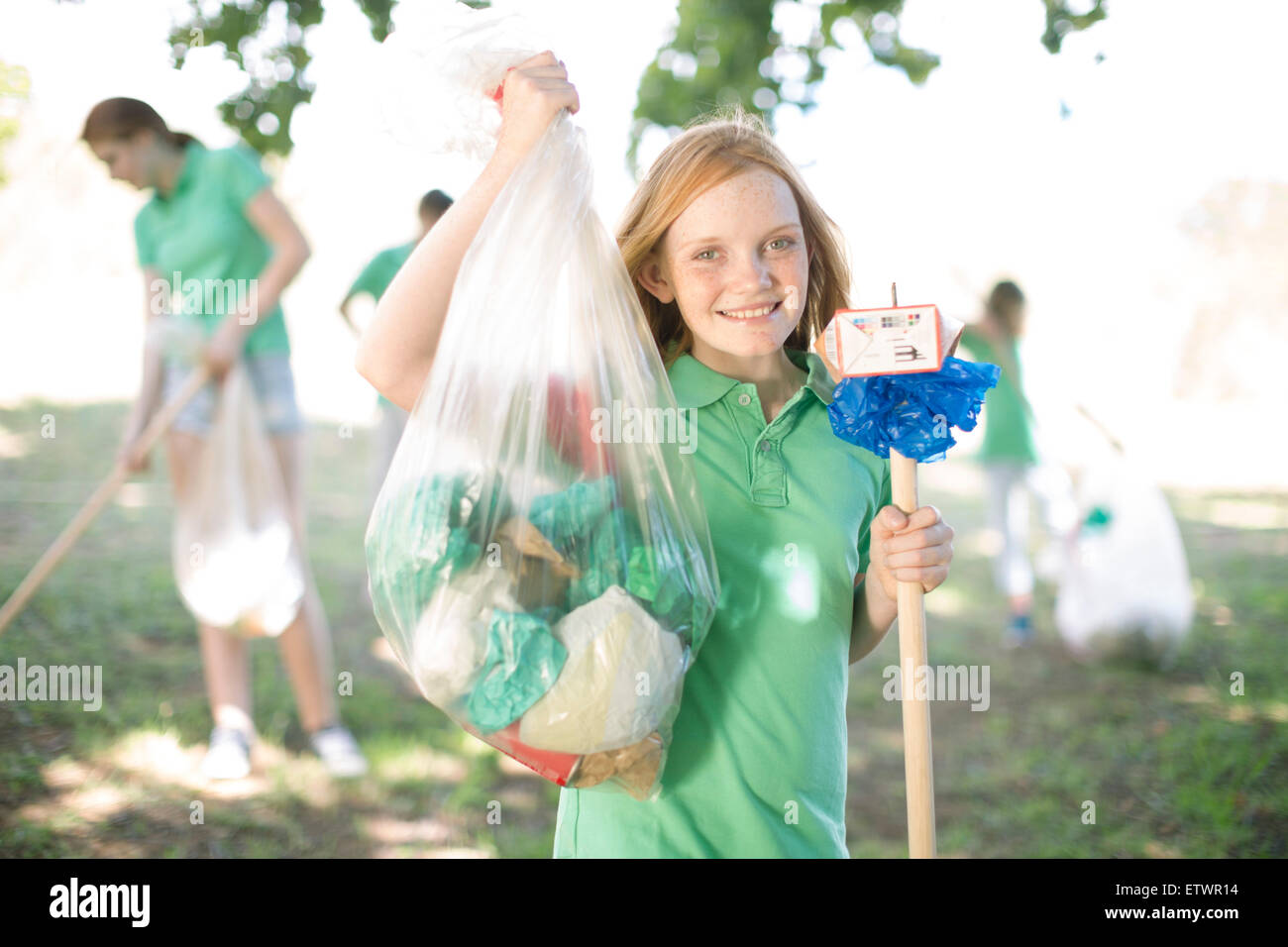 Portrait of smiling girl showing picked up garbage Stock Photo Alamy