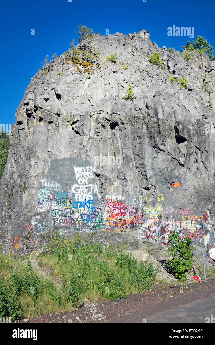 A rock cliff in the Oregon Cascade Mountains that people have covered with graffiti. Stock Photo