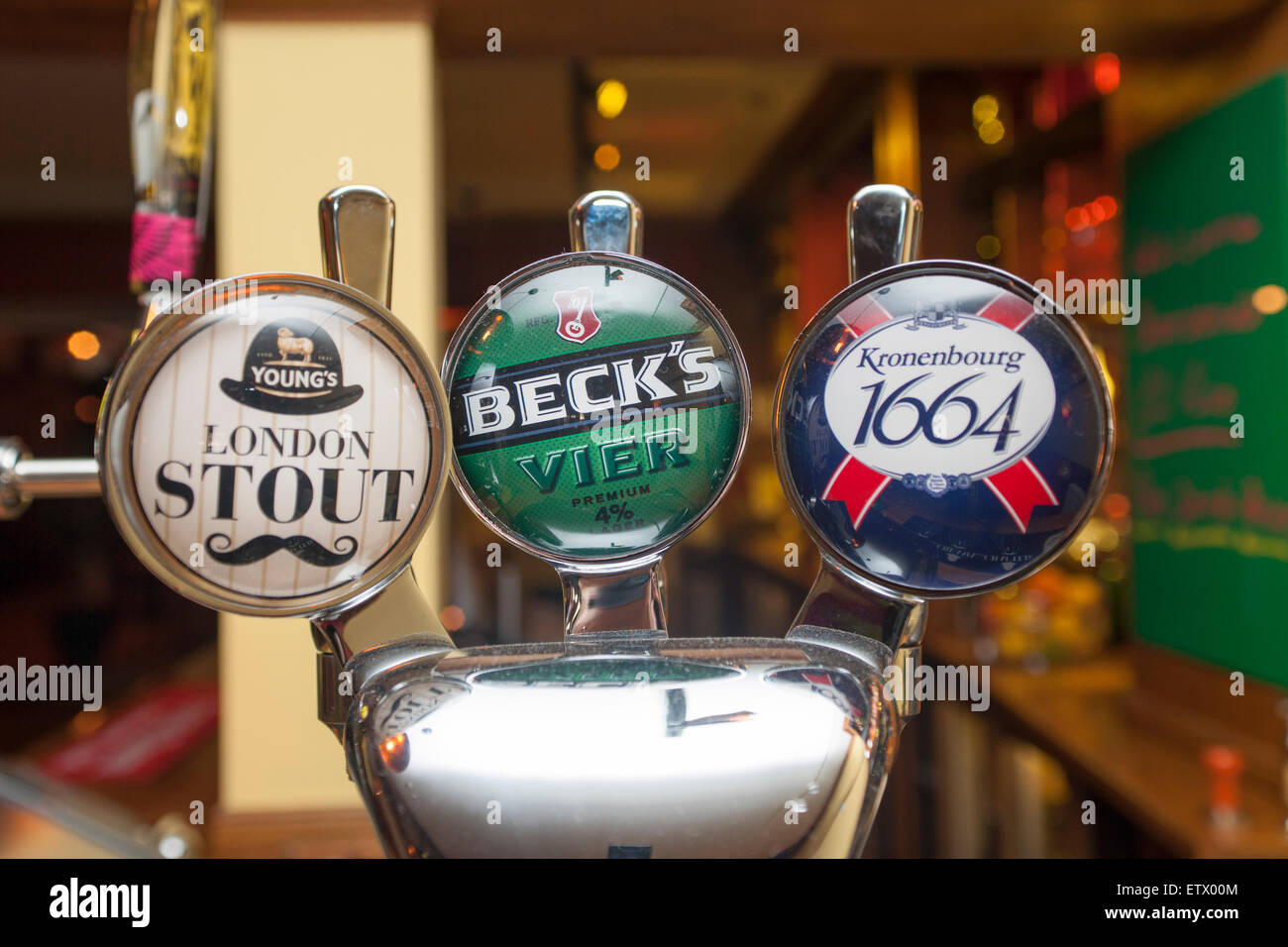 Pub beer pump with London Stout, Becks, Kronenbourg 1664 beers. Stock Photo