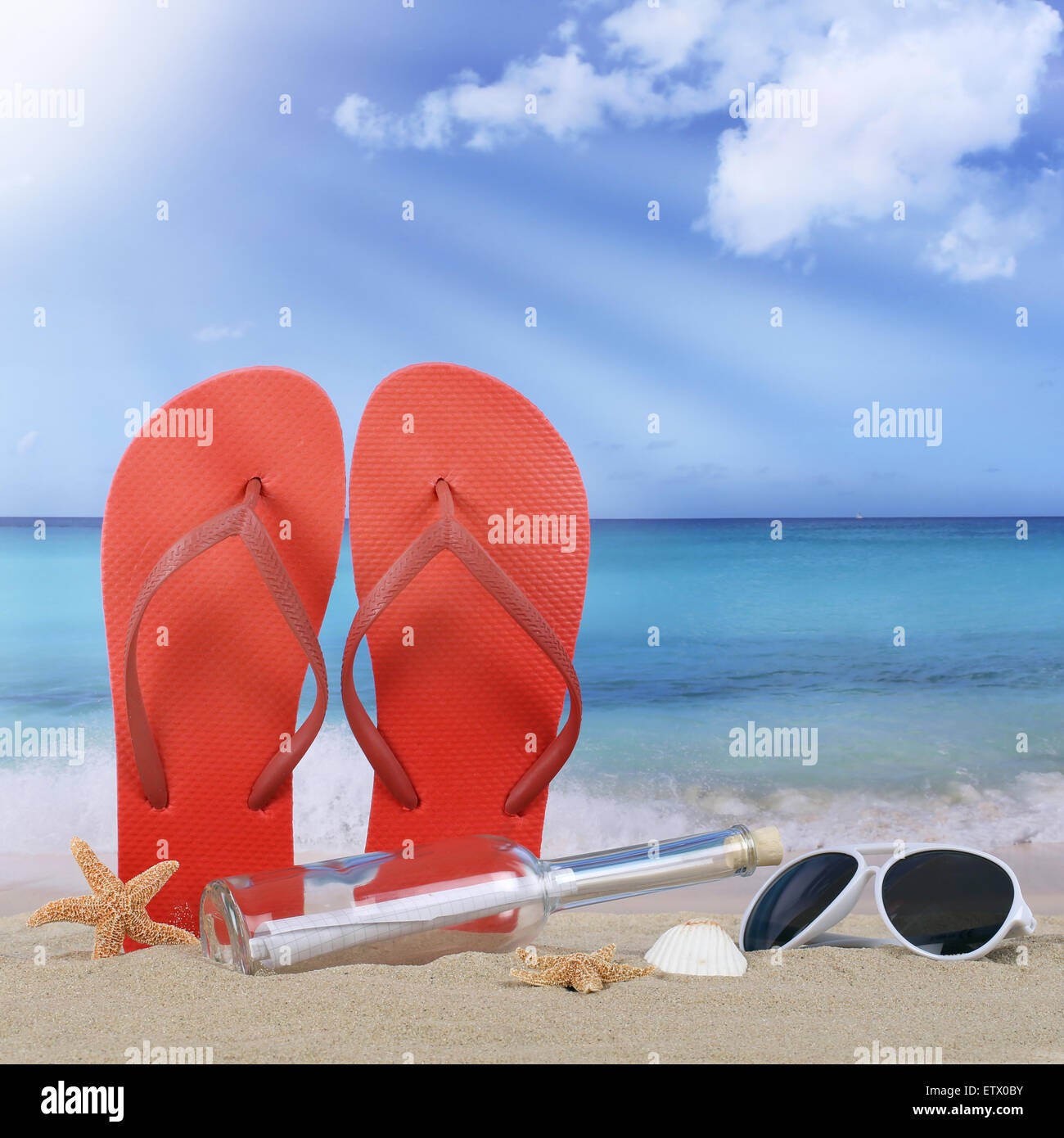 Beach with flip flops sandals and bottle post in summer vacation travel, holidays Stock Photo
