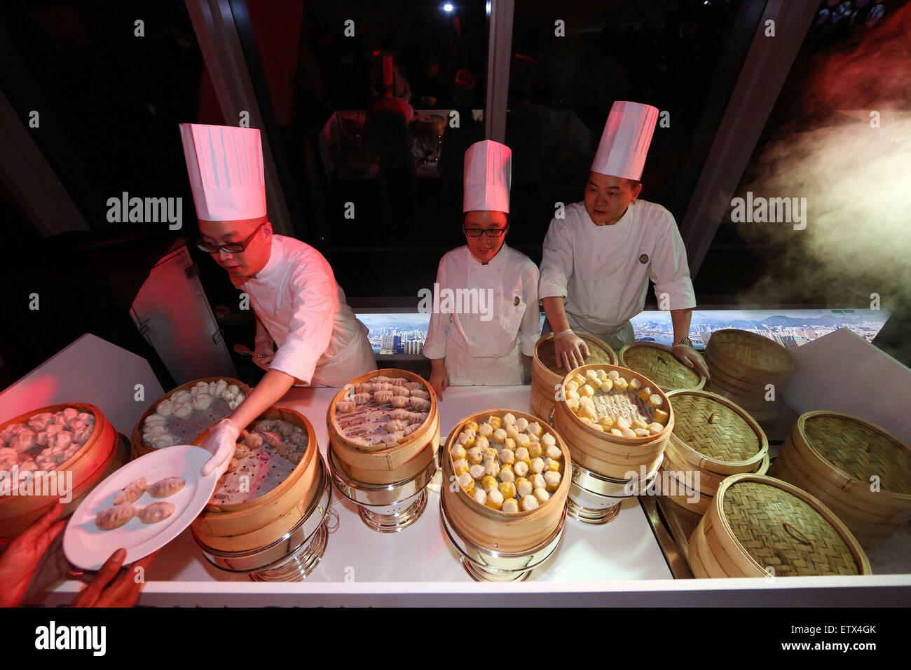 Hong Kong, China, Cook reaches a guest a plate of dim sum Stock Photo